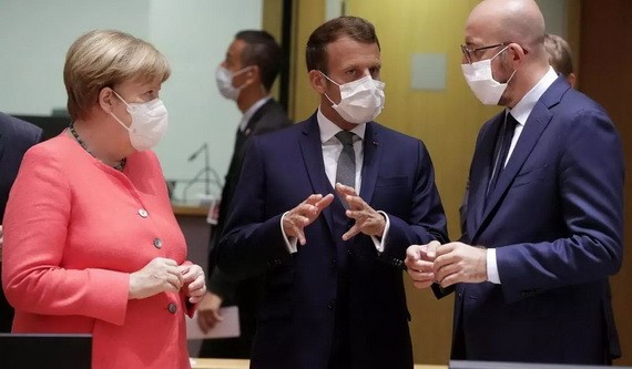 法國總統馬克龍（中）與德國總理兼歐盟輪值主席默克爾（左）在歐盟峰會進行談判。（圖源：路透社）