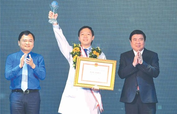 市人委會主席阮成鋒（右）向大水鑊醫院重症監護室吳越英醫生頒授2020年本市年輕公民模範獎座及獎狀。（圖源：越勇）