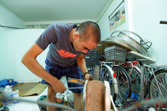 吳戰勝在租房裡修理舊自行車。