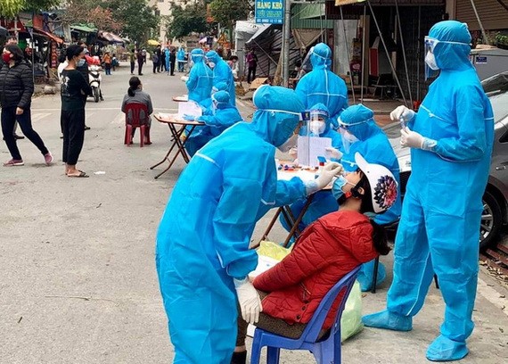 防疫工作人員對海陽省金城縣金蓮鄉的疫區居民進行鼻拭子取樣測試。（圖源：T. Thắng）