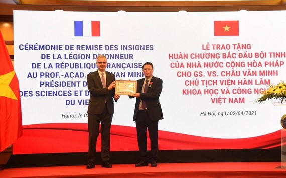 法國駐越南特命全權大使（左）向周文明教授（右）頒授北斗星勳章。（圖源：阮懷）