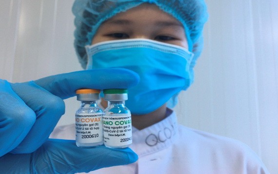 一名醫務人員拿著兩小瓶國產新冠疫苗。（圖源：冰心）