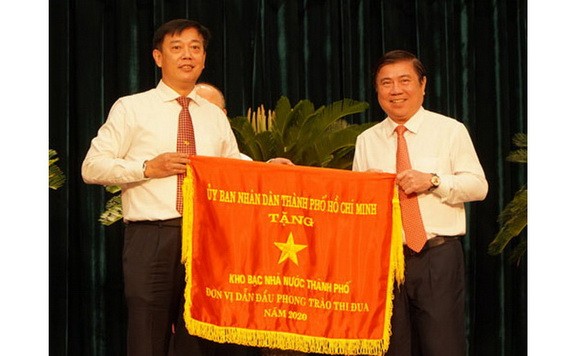 市人委會主席阮成鋒（右）向取得本市2020年競賽運動出色成績的單位頒發競賽錦旗。