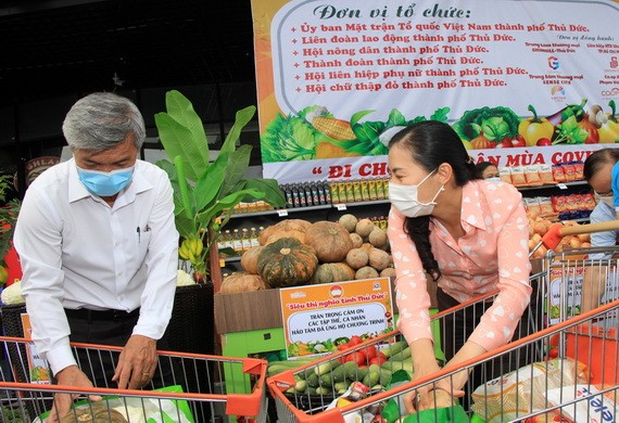 市越南祖國陣線委員會副主席潘嬌清香(右)為市民選購食品。