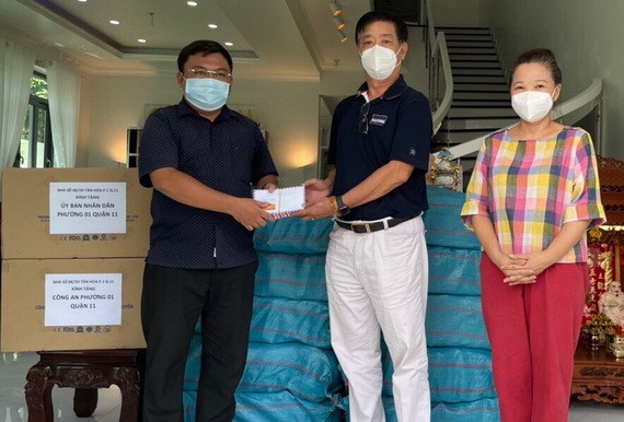 華人熱心人士鄧栢榮、區美莉伉儷(右)向第十一郡第一坊領導移交支持防疫物資。