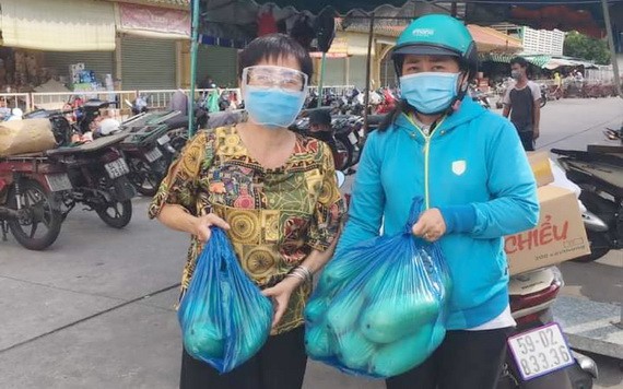 華人商販應氏蓮(左)將募集到的蔬菜送給隔離區居民。