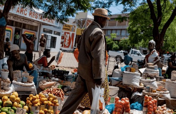 一名男子走過布拉瓦約露天市場的水果攤。（示意圖：互聯網）