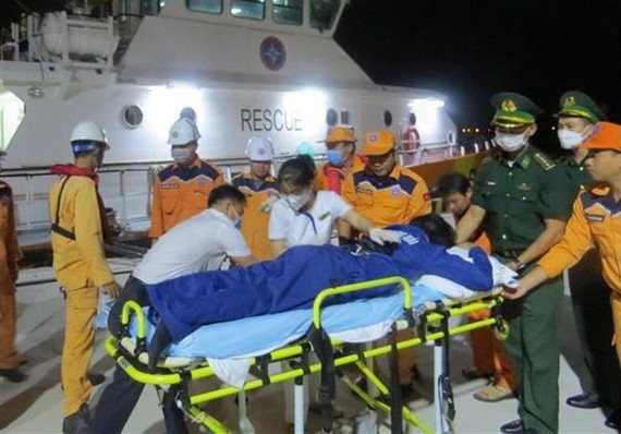 救護隊伍將海上遇險的船員送上岸救治。（圖：越通社）