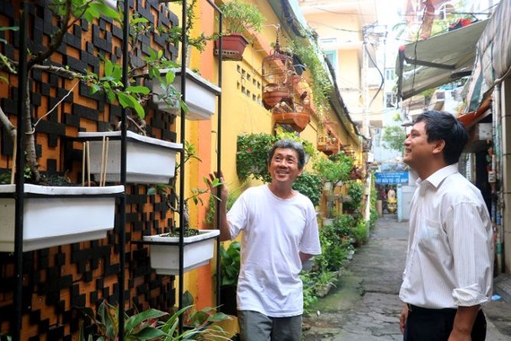 林成忠(左)向張俊協介紹有關二維碼圖的種花牆壁設計構思，以掀起市民在抗疫這段堅強日子回憶。