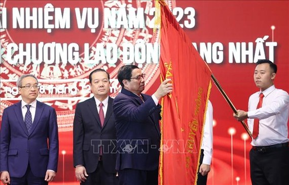 政府總理范明政在新聞與傳播部傳統旗幟別上一等勞動勳章。（圖：越通社）