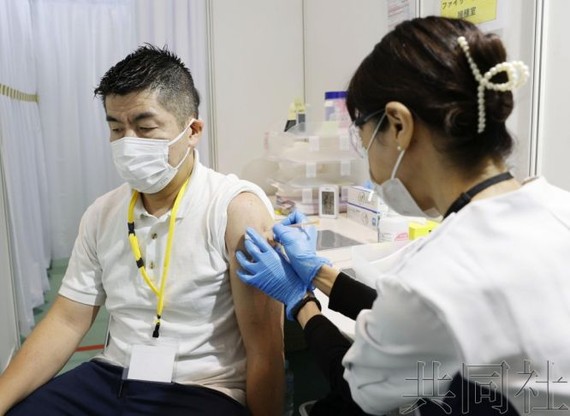 10月14日上午，一名男性正在接種應對新冠疫苗奧密克戎毒株亞型“BA.5”的疫苗。（圖：共同社）
