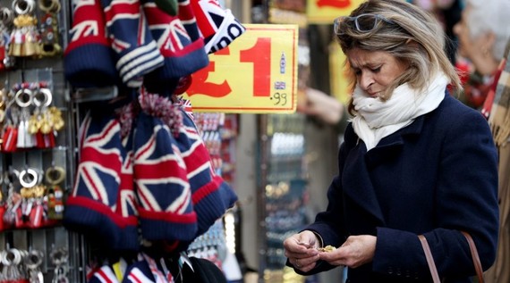 图为2022年11月25日，一名妇女在英国伦敦牛津街上购物。（图：新华社）