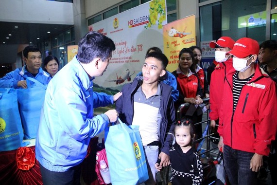 乂安省劳动联团领导在机场问候和赠送春节礼物给返乡贫困劳工。（图：越通社）