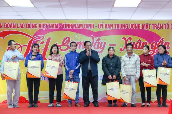 政府总理范明政向劳动工人赠送新年礼物。（图：VGP）