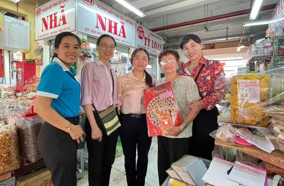 市妇联会副主席陈氏芳华向华人商贩应氏莲赠送春节礼物。