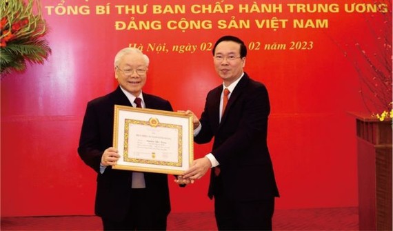 党中央书记处常务书记武文赏向党中央总书记阮富仲颁授55年党龄纪念章。