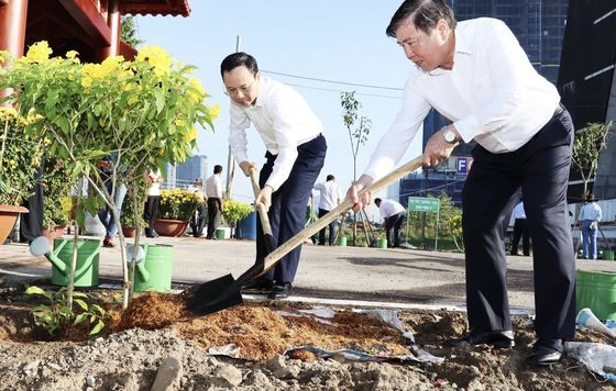 市人委会原主席阮成锋与市委副书记阮文孝参加植树活动。