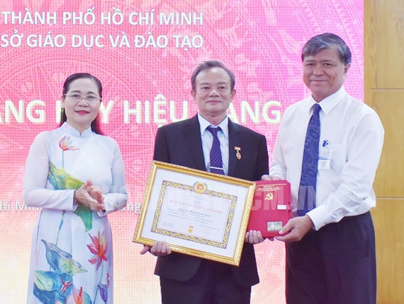 市人民议会主席阮氏丽向范玉茂同志颁授50年党龄纪念章。（图：市党部新闻网）