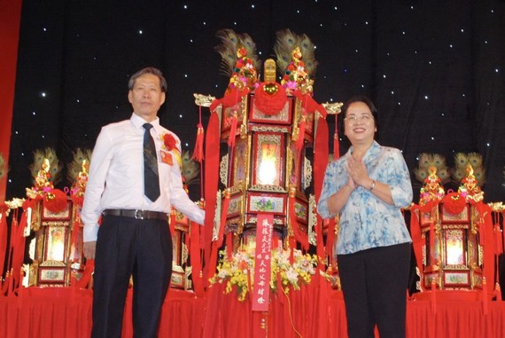 市越南祖国阵线委员会主席陈金燕向该会馆常值副理事长陈振炎移交“天地父母财灯”。