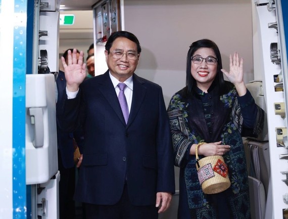 政府总理范明政偕夫人抵达新加坡。（图：越通社）