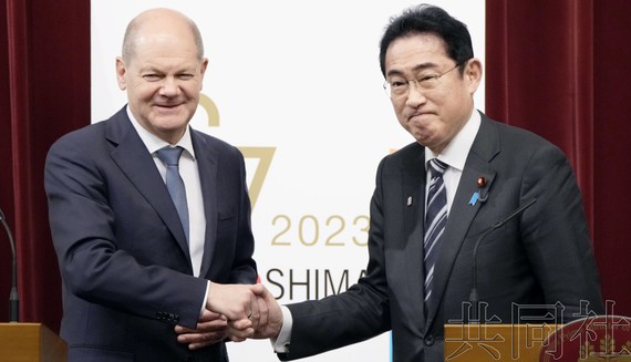 3月18日晚，日本首相岸田文雄（右）和德国总理朔尔茨在首相官邸举行联合记者会后握手。（图：共同社）