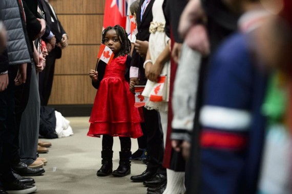 一批新加入加拿大的移民在渥太华国会山庄宣誓入籍后唱国歌。（图：AP）