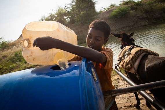 在苏丹南部白尼罗州，一名男孩从修复后的集水池取水。（图：联合国）