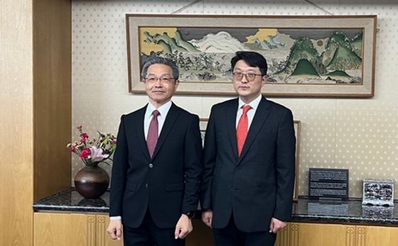 3月23日，在日本东京，韩国科技部电波政策局长崔佑赫（右）和日本总务省事务次官竹内芳明举行会晤前合影留念。（图：韩联社）