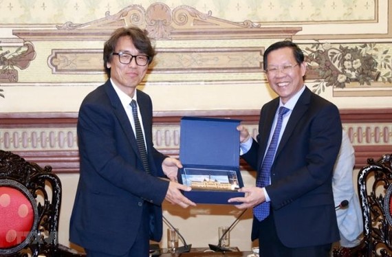 市人委会主席潘文迈（右）向韩国环境部副部长金恒升赠送纪念品。（图：越通社）