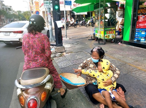 一名妇女携带着小孩呆在阮廷炤与阮善术街角口行乞。