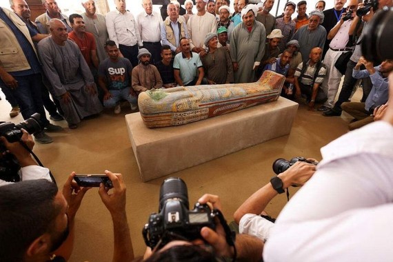 埃及考古人员、官员与刚从墓葬中出土的棺椁合影。（图：路透社）