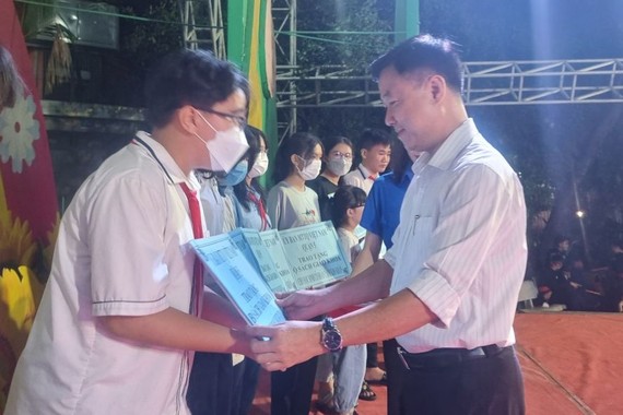 第五郡越南祖国阵线委员会主席黎晋才颁赠礼物给少儿。