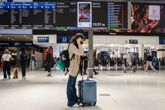 当地时间2023年6月2日，英国伦敦，在英国铁路运输工会举行罢工行动期间，一名乘客在滑铁卢站等火车时查看手机。（图：互联网）