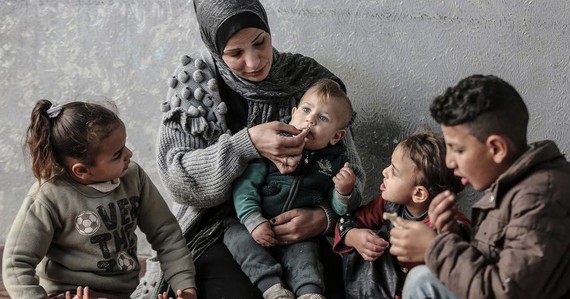 加沙的一个巴勒斯坦家庭分享用世界粮食计划署食品券购买的一顿饭。（图：联合国）