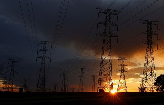 图为 2023年5月18日，在南非索韦托的奥兰多，由于燃煤电厂老化，南非公用事业公司 Eskom 经常停电，一名男子走在电线塔中。（图：路透社）