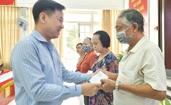 第五郡越南祖国阵线委员会主席黎晋才赠送礼物给老年人。
