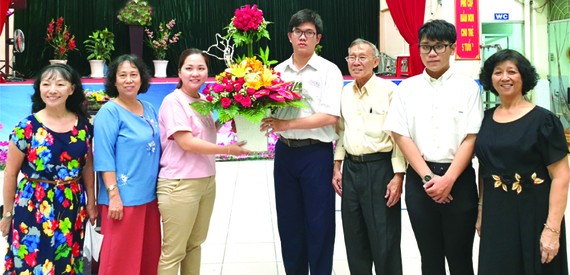 啟秀華文中心校委、老師和學生送花向亞洲餅家 及高慧芳小姐(左三)致謝。