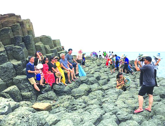 遊客在富安省碟石灘拍照。