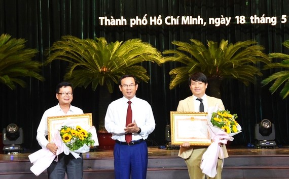 市委書記阮文年向年輕人出版社一成員有限責任公司代表和綠宇宙股份 公司經理黃俊英頒發政府總理授予的獎狀。