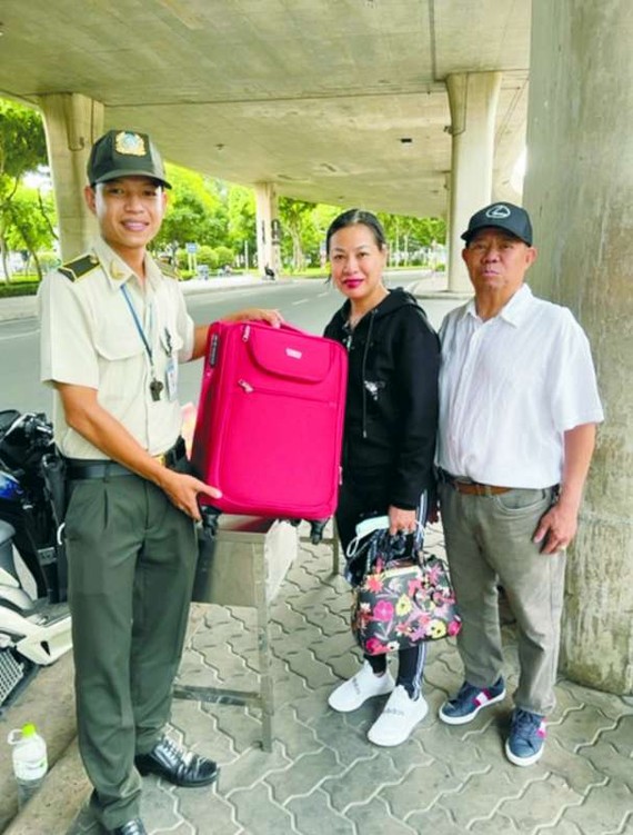 保安員梅國慶(右一)把行李箱交回失主。