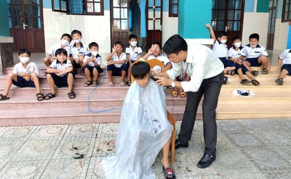 黎友平校長免費給學生修剪頭髮。