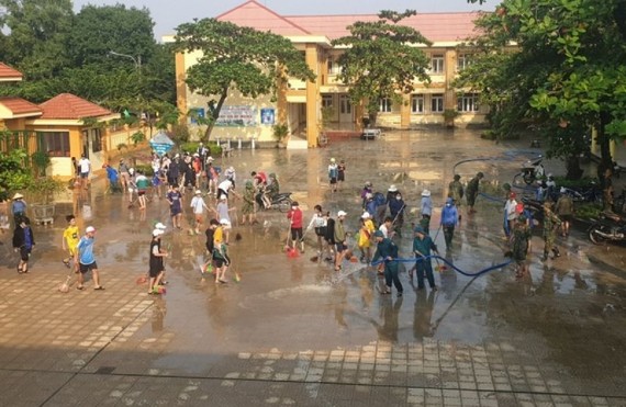 洪水退後，峴港市麗水縣各所學校的工作人員配合有關部門力量進行清潔校園。（圖：VOV）