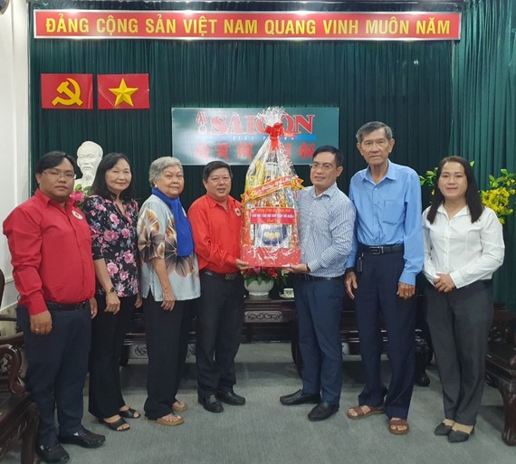 第八郡红十字会主席阮国明(左四)向报社赠送新年礼物。