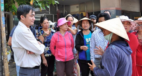 Phó Chủ tịch UBND quận Tân Bình phụ trách kinh tế nghỉ việc Ông Lê Thanh Bình (bìa trái) lúc còn là Phó Chủ tịch UBND quận Tân Bình đang lắng nghe ý kiến của tiểu thương chợ Tân Trụ (phường 15) khi quận xử lý lấn chiếm vỉa hè, lòng đường. Ảnh: KIỀU PHONG