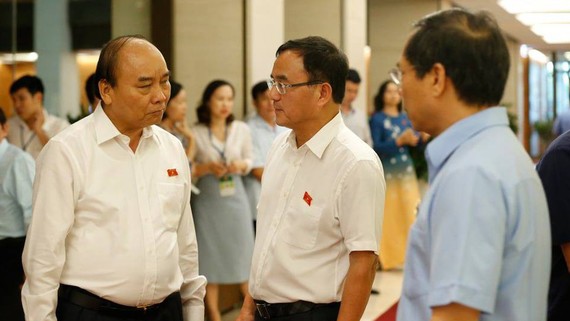 Hoãn tăng lương chỉ nên là giải pháp tình thế  Thủ tướng Nguyễn Xuân Phúc trao đổi với các ĐBQH ngày 13-6. Ảnh: QUANG PHÚC