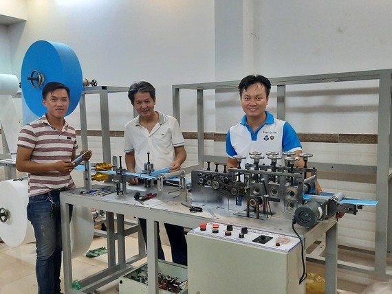 Khoa Cơ khí Trường ĐH Bách khoa TPHCM: Chế tạo thành công máy làm khẩu trang y tế PGS.TS Nguyễn Hữu Lộc (giữa) và TS Nguyễn Thanh Hải (phải) bên máy tạo thân khẩu trang y tế.