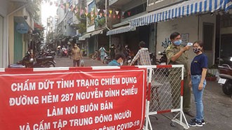 Chống dịch ở địa bàn dân cư Đo thân nhiệt người dân ra vào khu chợ tự phát hẻm 287 Nguyễn Đình Chiểu (phường 5 quận 3)