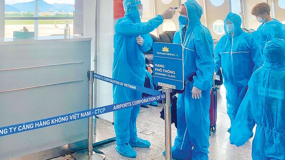 Coi trọng yếu tố an toàn khi mở lại đường bay quốc tế Kiểm tra thân nhiệt hành khách trước khi vào phòng chờ. Ảnh: HOÀNG HÙNG