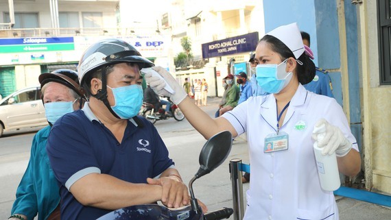 Người dân đến thăm khám tại Bệnh viện Da liễu TPHCM đều được đo thân nhiệt ngay từ cổng bệnh viện