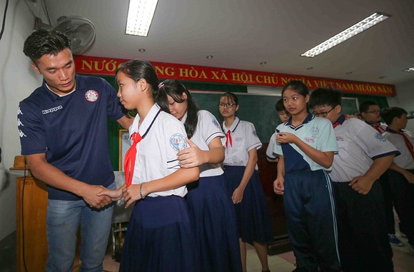 Thủ môn Bùi Tiến Dũng và đội trưởng Văn Thuận sẻ chia với học sinh gặp tai nạn trường THCS Bạch Đằng ảnh 4